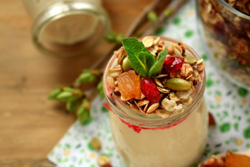 Yogurt in a glass jar topped with granola and mint