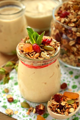 Yogurt in a glass jar topped with granola and mint