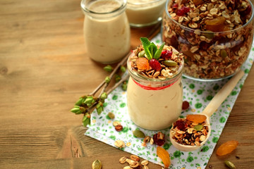 Obraz na płótnie Canvas Yogurt in a glass jar topped with granola and mint