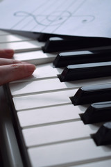 Fototapeta premium Black and white piano keys and musician's hands playing a tune
