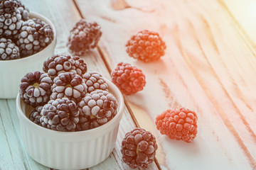 Frozen Dewberries in hoarfrost on rustic wooden table5. Close up