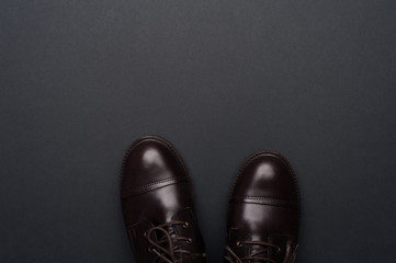 Dark brown man shoes on grey background. Flat lay, top view