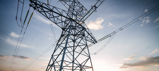 high voltage power line is on the background of the blue sky