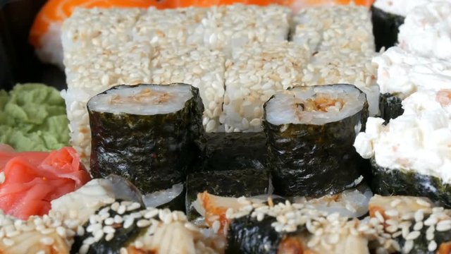 Camera zooms. A lot of different Nigiri Gunkan Maki Sushi with eel salmon Philadelphia cheese cucumber close up view