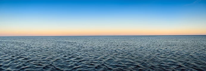 Poster Panorama of sea waves on the background of dawn © Oleksandrum