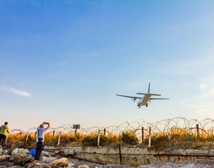 People photographing a turboprop airplane landing at Larnaca International Airport