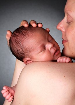 baby in mothers arms stock photo