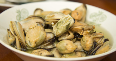 Tasty oiled pickled mussels iin a plate on the table