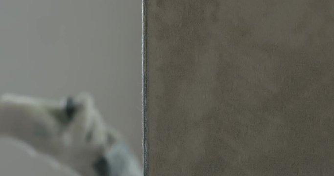 Slow motion worker applying putty on the wall with copy space