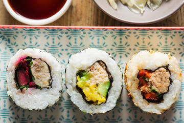 Sushi - California roll with tuna, mackerel, crab, pepper, beetroot with soy sauce and pickled ginger