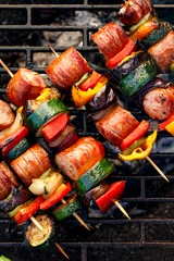 Zelfklevend Fotobehang Gegrilde spiesjes van vlees, worstjes en verschillende groenten op een grillplaat, buiten, bovenaanzicht. Gegrild eten, bbq © zi3000