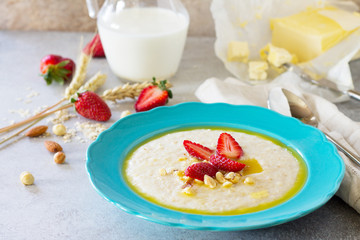 Porridge of oatmeal with nuts and fresh strawberries on stone or slate background. The concept of nutrition health. Healthy breakfast.