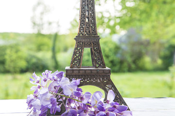 Eiffel tower in the green park with purple wisteria