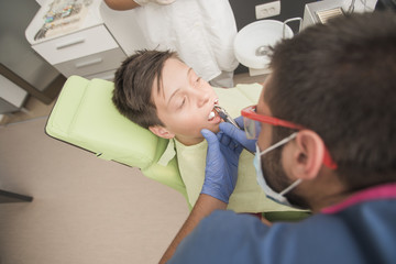Teenager having his tooth removed at the dentist office - oral hygiene health care concept