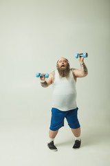 Man exercising with dumbbells while wearing headphones