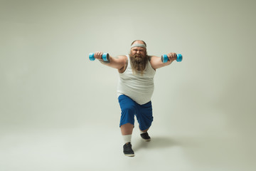 Man with beard exercising with dumbbells