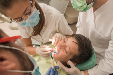 Boy with perfect teeth at the dentist doing check up with the clinic at the background - oral hygiene health care concept