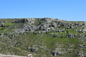 Fototapeta na wymiar Italy, Basilicata, Matera, city of stones, Unesco heritage, capital of European culture 2019. Hill with ancient caves in front of the city, on the river gravina