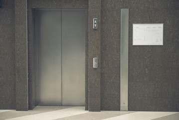 Close up evacuation plan situating on brown wall near silver elevator