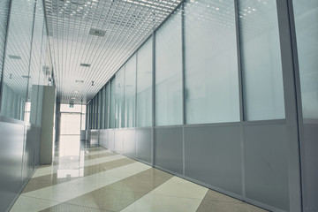 Design of long bright hallway with colourful floor and glass walls