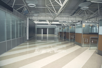 Interior of huge hall with cabins with metal structures near them and striped floor