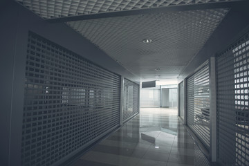 Wide grey long corridor with bright modern door at end of it