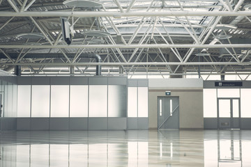 Wide light hall with grey door and concrete floor. Warehouse concept