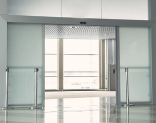 Wide bright modern office with opened glass door and wide windows