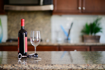 A photo of a wine bottle, a wine glass and a bottle opener