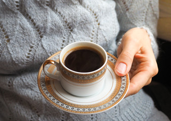 A Cup of black coffee in the hands of close-up.