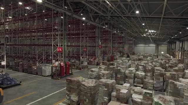 Aerial view of interior of new large and modern warehouse space. Rows of shelves with boxes. Retail industry, shipment and logistics concept.