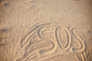 The inscription on the sand beach SOS