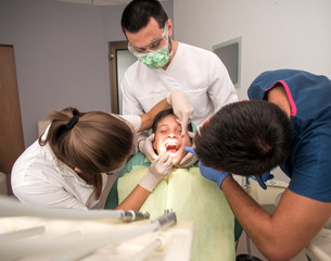 Obraz premium Boy with perfect teeth at the dentist doing check up with the clinic at the background - oral hygiene health care concept