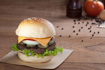 Close up of beef burger with cheese on wood table.