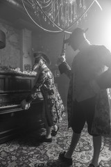 Actors in Steam punk masks and antique costumes indoor. Black-white photo.