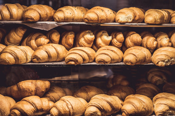 Fresh baked croissants on a showcase in a bakery shop