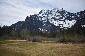 Obraz premium Snowy mountains, pristine alpine lake, evergreen forest