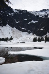 Snowy mountains, pristine alpine lake, evergreen forest