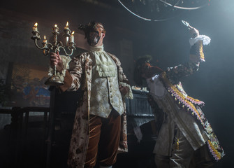 Actors in Steam punk masks and antique costumes indoor.