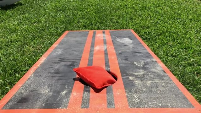 Home made Cornhole backyard game close up with dust cloud flying in air