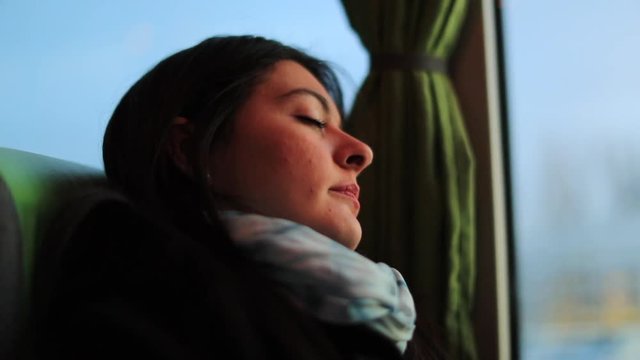 Woman asleep while traveling by bus. Passenger girl sleeping while riding onibus