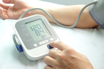 A man check blood pressure monitor and heart rate monitor with digital pressure gauge. Health concept