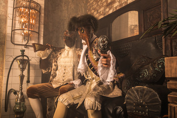 Actors in Steam punk masks and antique costumes indoor.