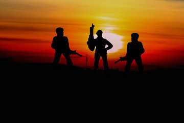 Silhouette Soldiers  with sunset and copy space add text ( Concept stop hostilities To peace)