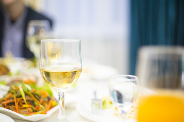 Glass of champagne on a festive evening party table with beautiful boken and copy space for text