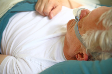 Obraz na płótnie Canvas Closeup of senior man napping with a CPAP attachment