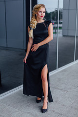 Attractive lady in long evening dress on the street