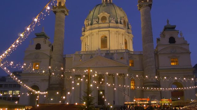 Tilt down of a Christmas market in front of Karlskirche
