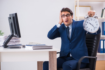 Businessman employee in urgency and deadline concept with alarm 