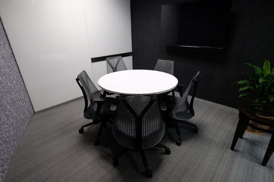 Small meeting room for five people with whiteboard and television accessory